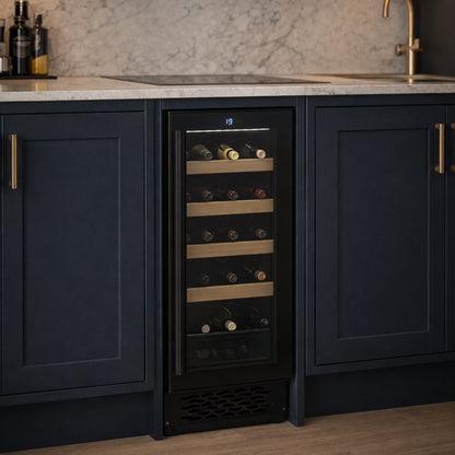Wine cooler integrated into a kitchen with dark cabinets and marble backsplash.