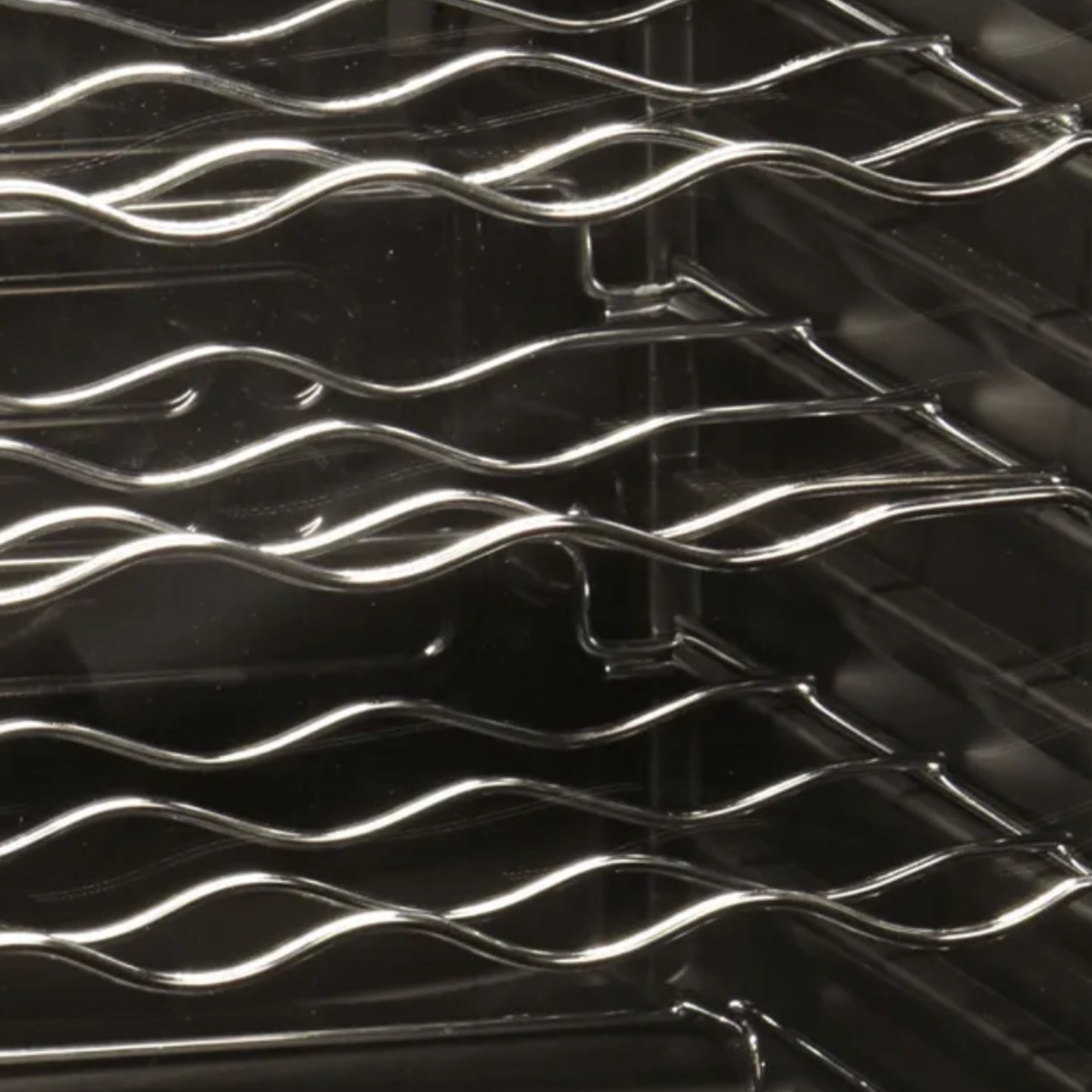 Metallic grill with wavy design on a black background