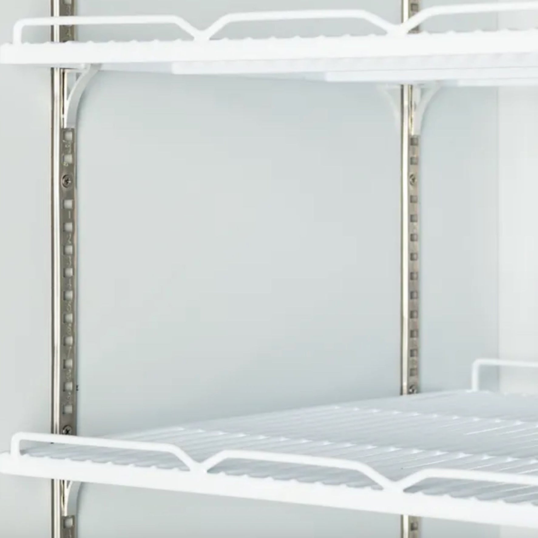 Metal shelving unit with white wire shelves on a plain background