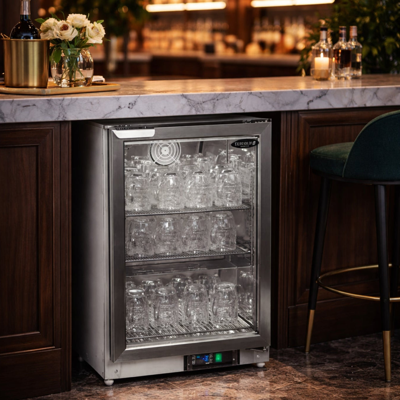 Beverage cooler in a bar setting with marble countertop and wooden cabinets.